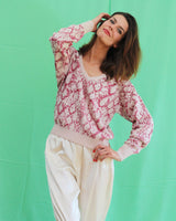 pullover laine cachemire ecru avec motif serpent en rose, col v et manche longues